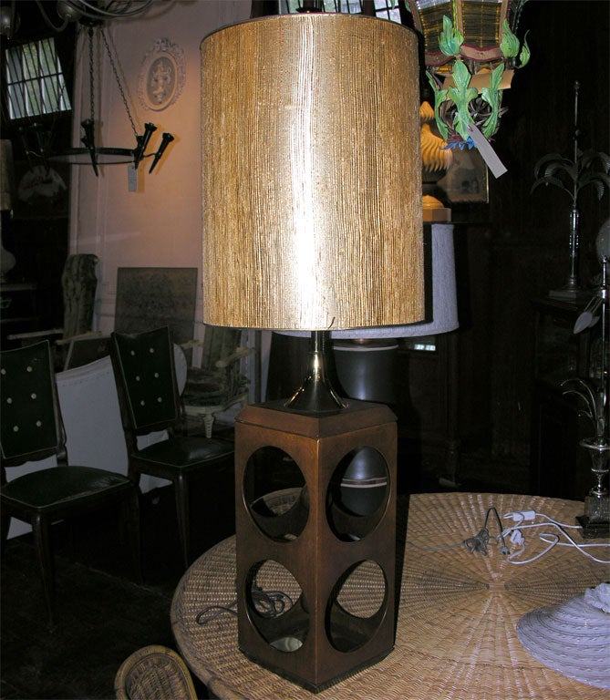 Rectangular wooden lamp with large circular cutouts. Original gilt grass cloth drum shade.