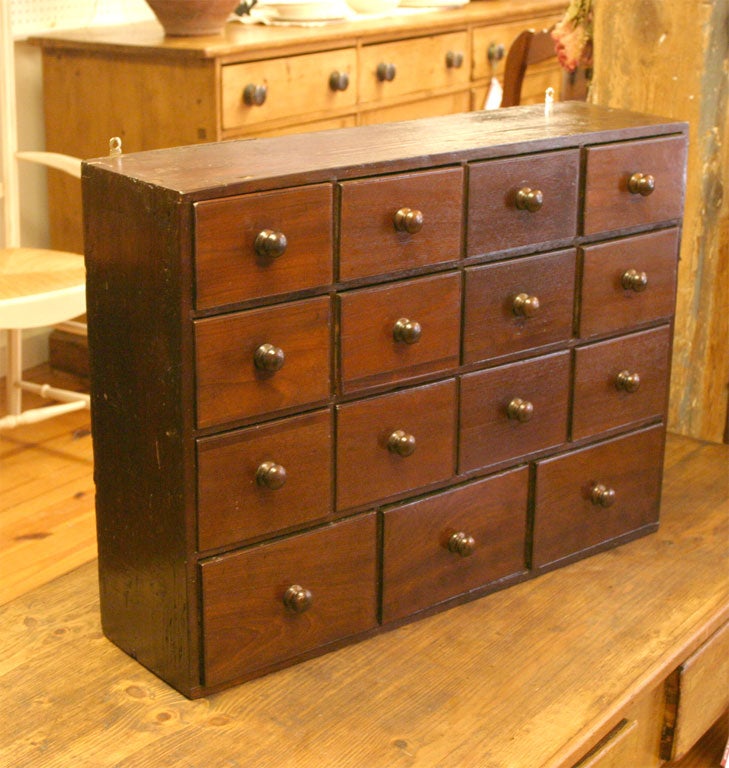 This delightful little bank of spice drawers is from France. It has three rows of four small drawers and below them are three larger drawers, all with wood pulls.