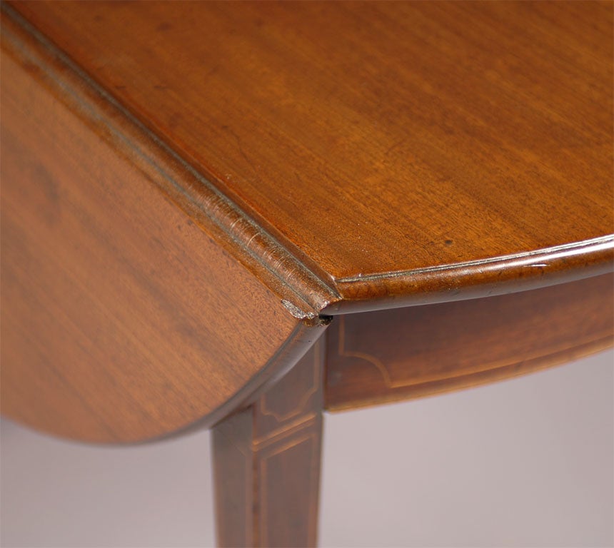 An English Pembroke table in Mahogany with Boxwood stringing inlay, dating from the Regency Period.<br />
<br />
The table mounted on four tapering square legs with inlay, each ending in brass castors. <br />
<br />
The frieze containing one