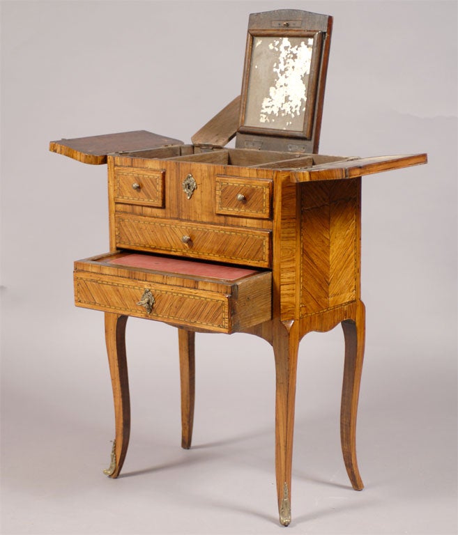 A petite Louis XV-Louis XVI dressing table in tulipwood. The exterior highlighted with delicate inlay of various woods on the front, sides, and top. The body retaining the original interior compartments and mirror. 

 

 