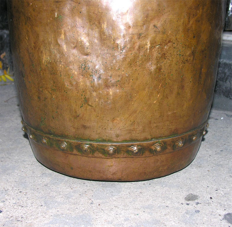 A late 18th century English cauldron of hand-beaten and well-worn copper with hammered lip and rivetted seams. Nice bronzed finish. Useful for kindling next to a fireplace.