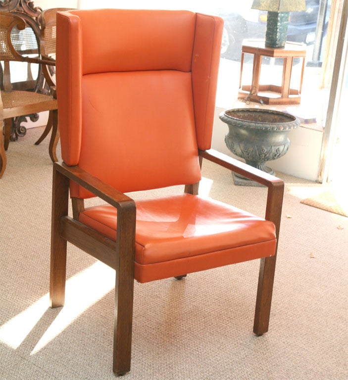 Here is a great wood framed wing chair covered in an orange faux leather.
