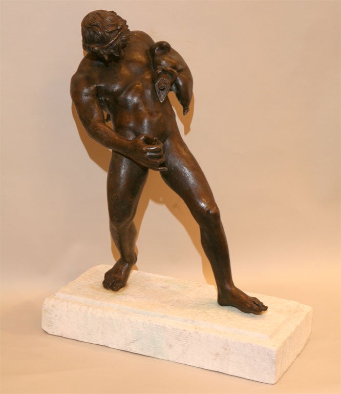 A ANTIQUES NEAPOLITAN BRONZE FIGURE OF A YOUNG FAUN WITH WINE SACK, BY SOMMER, NAPLES ON WHITE MARBLE BASE.