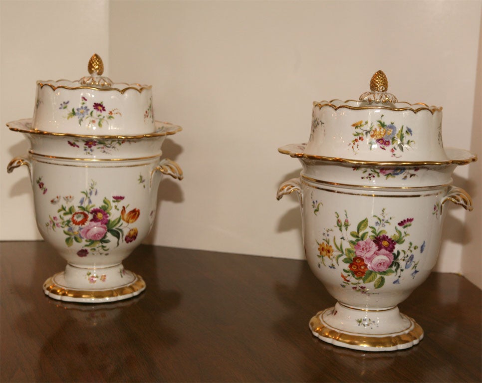 A wonderful matched pair of porcelain fruit or ice cream coolers with all original top and inserts. Decorated with hand-painted detailed floral subjects and highlighted with gold trim over pineapple finials. Unmarked but attributed to Vieux Paris