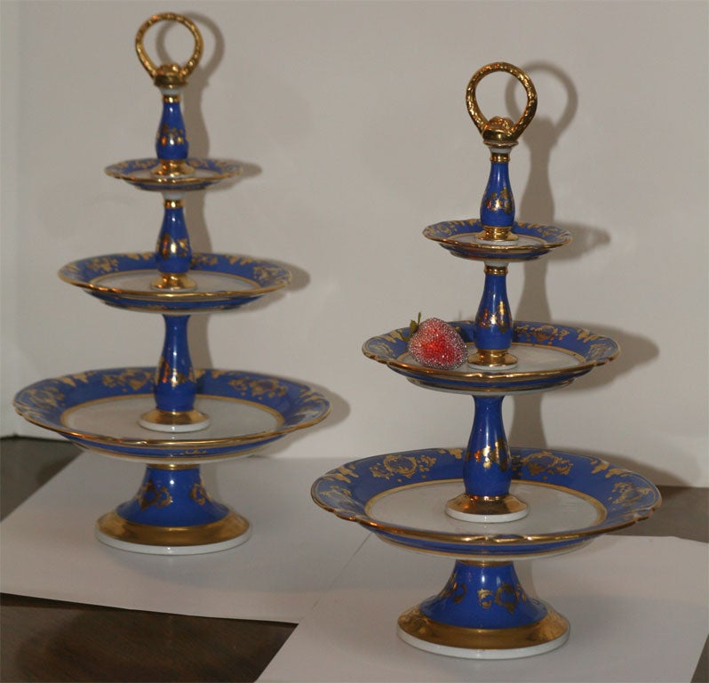Decorative and functional three-tiered porcelain dessert stands with bronze handle. Ultramarine blue with gilded decoration. Perfect for hors d'oeuvres, fruit and pastries.