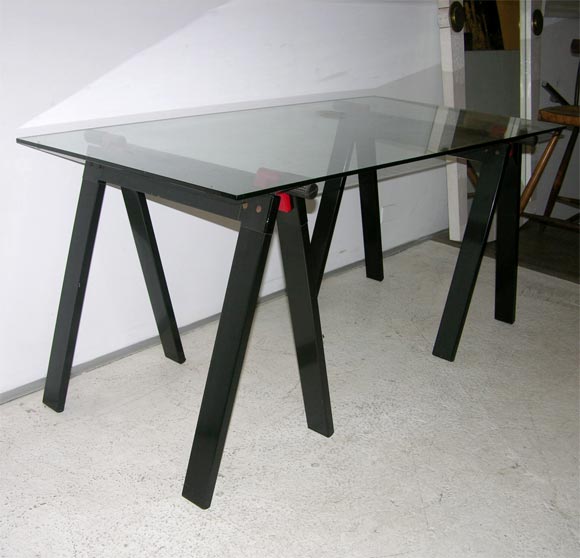 Gaetano working table by Gae Aulenti for Zanotta with original glass top,supported by two black and red enameled metal folding working horses alike base.Documented:see Repertorio Italian design book at page # 385.