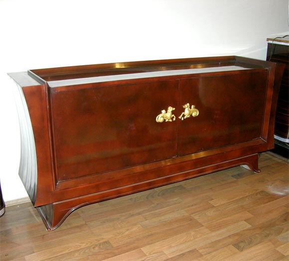 A French Art Deco buffet, from circa 1930s, attributed to René Drouet. Finished in a cloudy brownish red lacquer with gilt griffon front details.