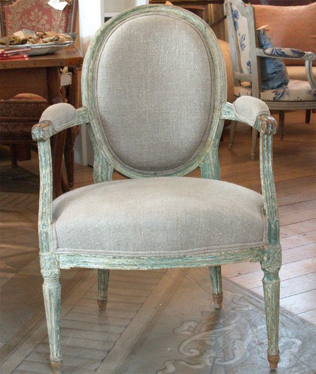 Painted green/beige finish on Louis XVI fauteuil,fluted legs.<br />
Upholstered in a taupe muslin.