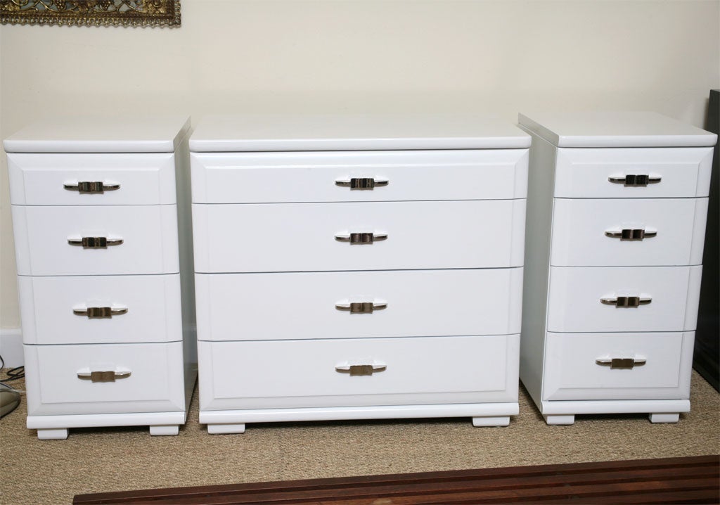 High gloss white lacquered chest of drawers with nickel silvered pulls. Pair of high gloss white lacquered side chests with nickel silvered pulls. Priced as follows; Single chest of drawers-$1,750.  Pair of side chests-$1,850.