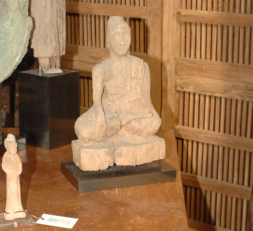 Teak Sitting Buddha on a bronze base. Very detailed considering age and that the piece was exposed to the elements for so many years. Like petrified wood. Wonderful expression and draping detail of the garment.