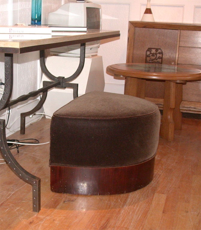 Chocolate velvet demilune ottoman with dark wood base.