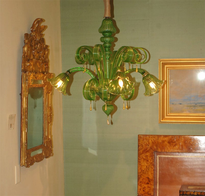 Early 20th Century Vibrant Leaf Green Murano Glass Chandelier with Four Lights, the Stylized Arms Culminating in Gilt Edge Tulip Cups, the Central with Swirling Ribbon Supports and 14K Gold Drops Surrounded by a Shaped Fluted Standard Culminating in