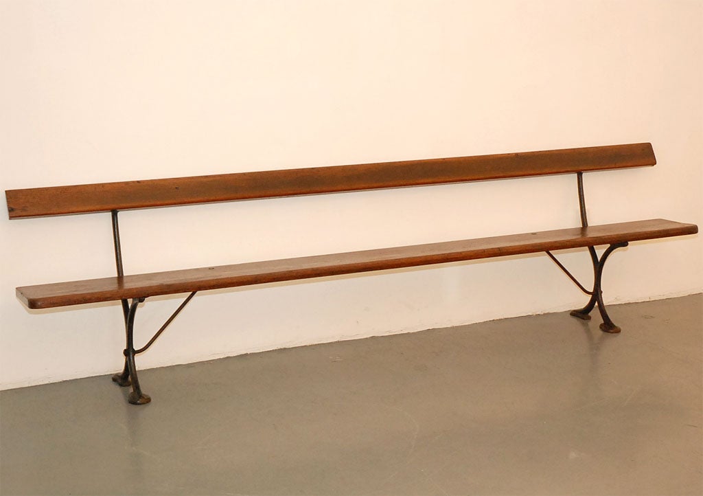 Great old railroad bench with iron legs and oak seat and back.  Beautiful patina and impressive scale.
