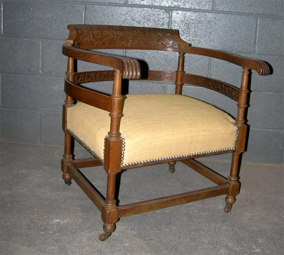Eastlake style walnut arm chair with raffia upholstery.Carved foral motif on back.