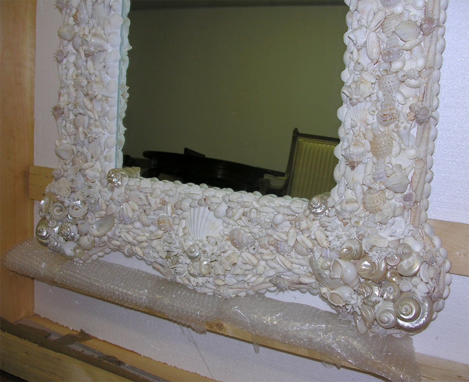 This is an extremely lovely, singular mirror created by Renzo Mongiardino. Decorated with sea shells of all shapes and sizes, it is many shades of white and luminously iridescent. Needs to be seen to be believed.