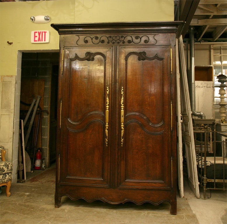 A fine 18th century Louis XV armoire in oak, with distinctive carving & inset paneled doors, a scalloped apron.