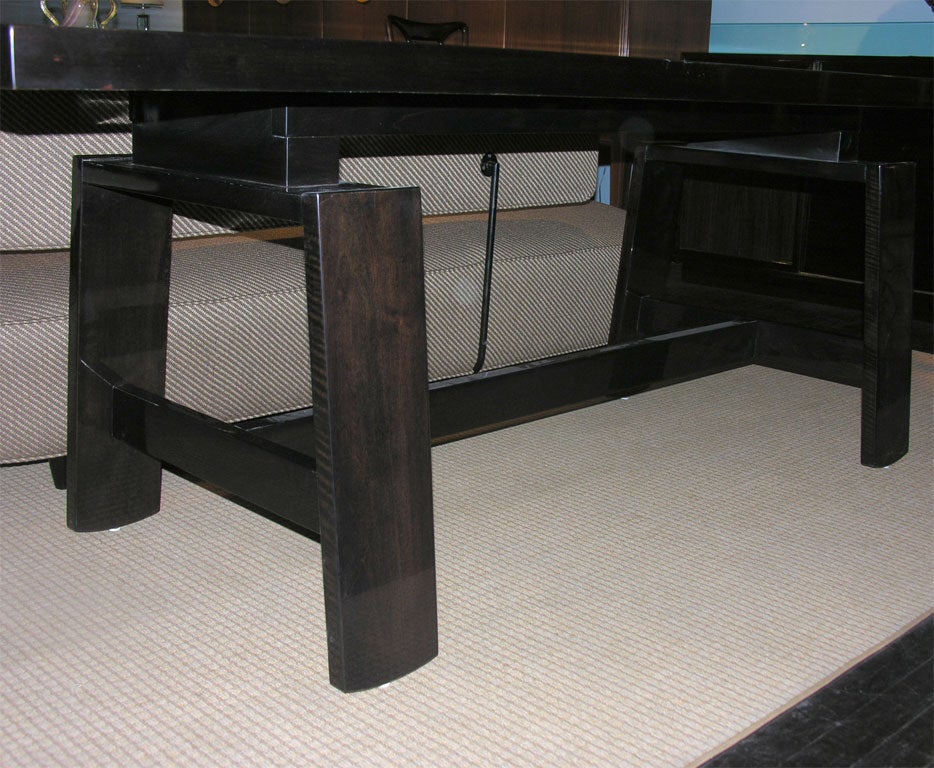 Tressel-style table with incised lines on top, suggesting inlaid planks.  Sculptural wide slat legs with curved bottoms.  Dark stained walnut, this table can be used as a writing table, dining, or as a console.