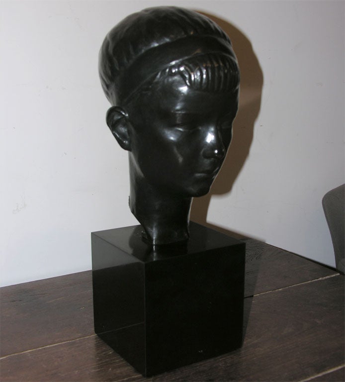A bronze bust of a youth in black bronze on a black marble pedestal. By Alexandre Wolkowyski, Russian sculptor, 1883-1961.
