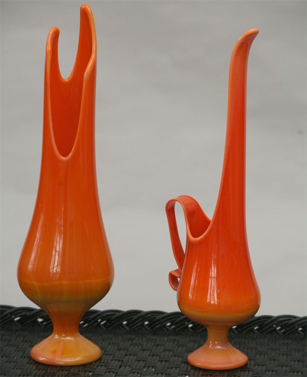 1960s Mod art glass:  elongated twin peaked vase and ewer (pitcher) with stretched pouring spout and curled glass handle.  This retro pair is authentic in form, style and coloring:  both are yellow-orange at bulbous base, changing to solid orange