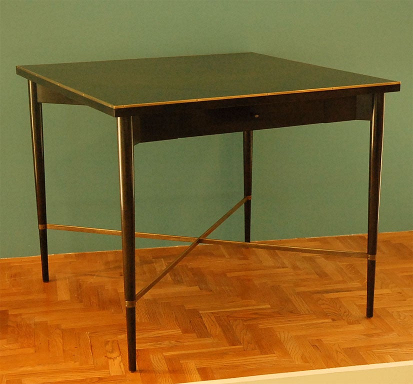 Ebonized mahogany Paul McCobb Game table with brass stretcher, hardware and edging.  One drawer to hold game pieces. Connoisseur Collection tag inside drawer.