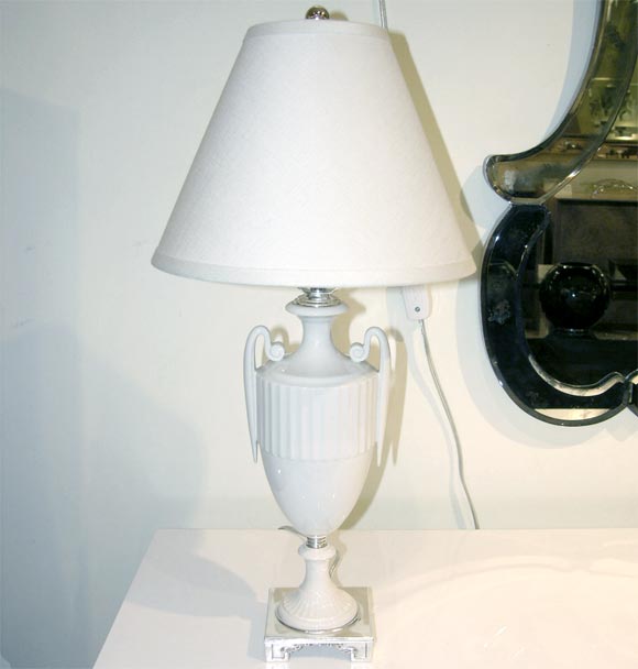 Stylized creme porcelain urn<br />
lamp with silvered bronze<br />
base and fittings. Recently<br />
featured in Sex And The City<br />
The Movie.