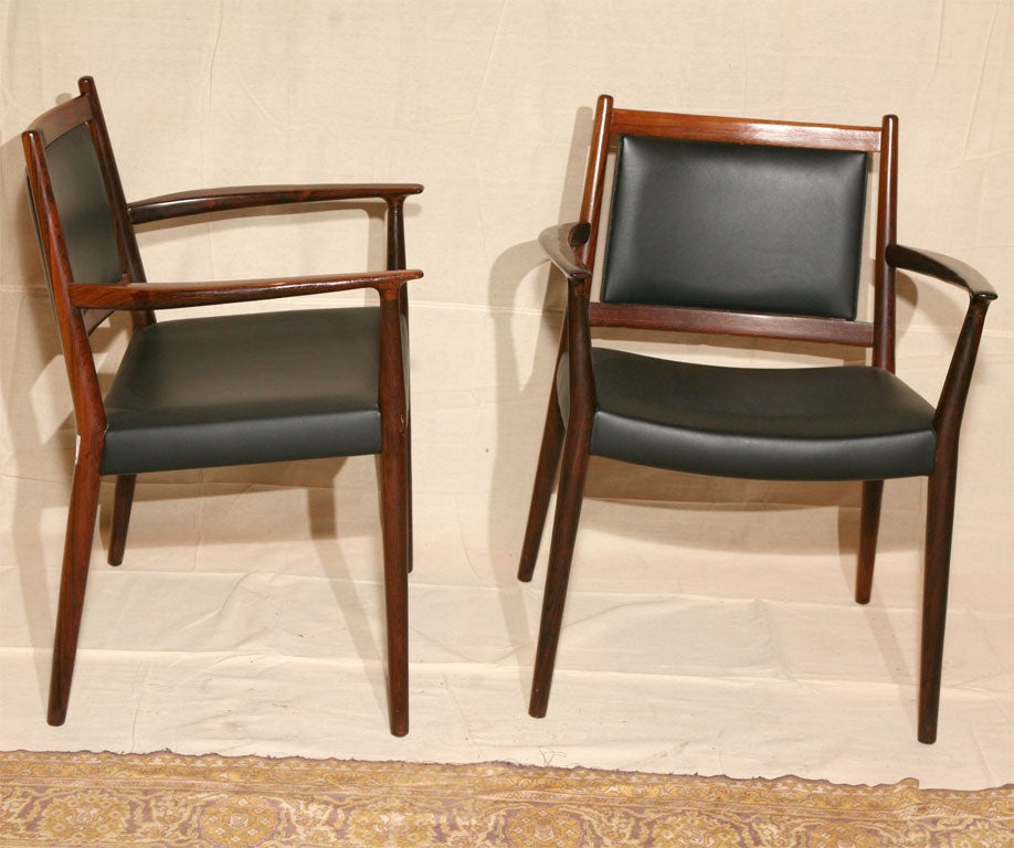 Pair of rosewood armchairs, upholstered in black leather by Danish architect, Steffan 

Larsen. Danish modern very high quality rosewood and fine quality black leather.  Great pair of 
desk chairs or occasional chairs