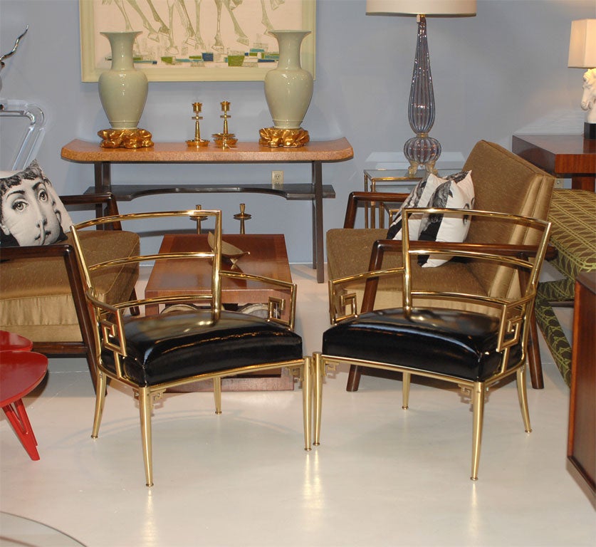 Pair of Italian polished brass greek key motif club chairs. Newly upholestered in black patent leather.