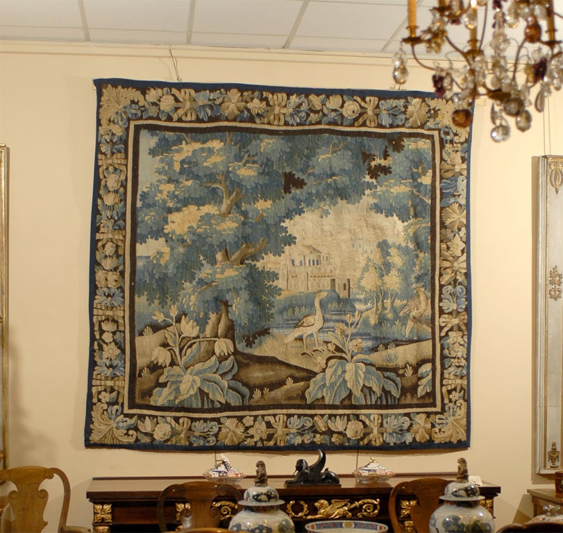 A fine and very large Aubusson tapestry, featuring a central Landscape scene elaborately depicting with exotic birds in the foreground, and a country home. The border with intertwined foliage design. 
The tapestry featuring a palate of blue, green