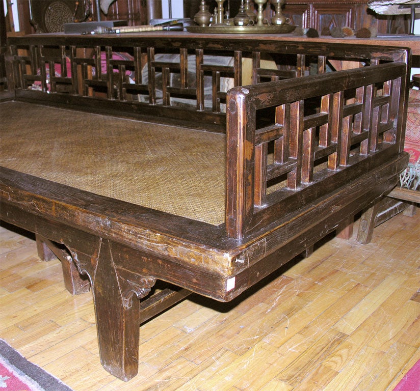 3 Sided elmwood opium bed with bamboo top and carved side motifs.