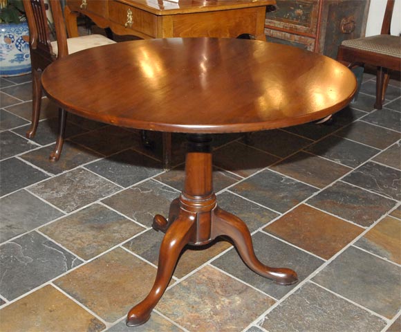 George II mahogany tripod table, the circular top on a birdcage support, raised on a circular standard to three cabriole legs, terminating in Dutch feet.