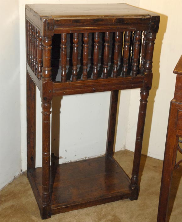 English oak livery cupboard with planked top and ring-turned spindle sides and front, incorporating a door on ring-turned elongated legs, joined by an undertier.