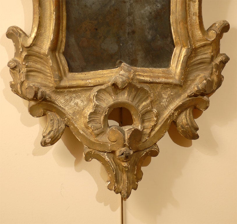 A fine pair of Gilt-wood Italian Girandoles, each frame embellished with crisp Rococo designs and surrounding a silver-backed mirror plate. <br />
<br />
Each gilt-wood with a crest of Acanthus leaves, and with a moulded edge design surrounding