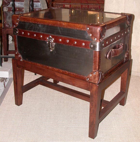 Well made steel trunk with leather trim on custom wooden base.<br />
There are 2 available.