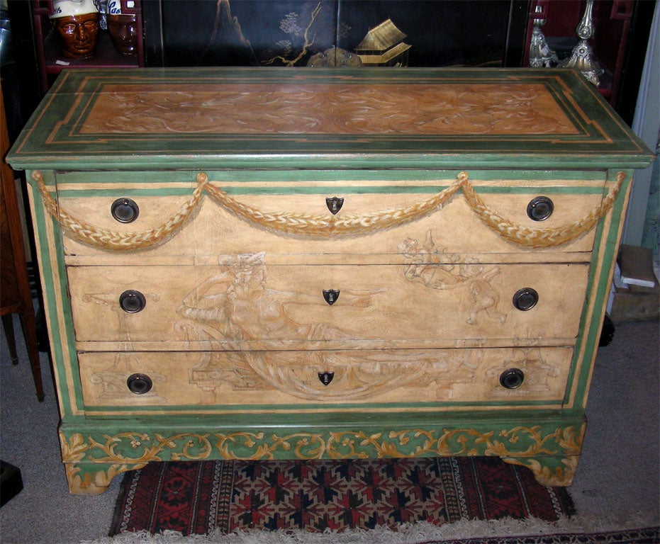 Commode with three drawers, decorated with antique-inspired images: swags over a reclining draped female holding a cup.
Repatinated.