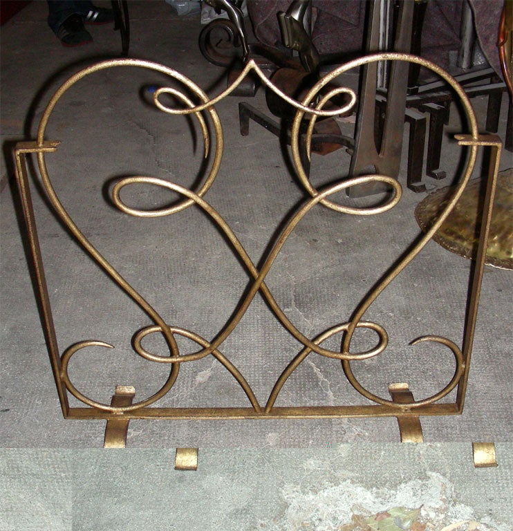 1940s fire screen by René Drouet in wrought iron gilded with gold leaf.