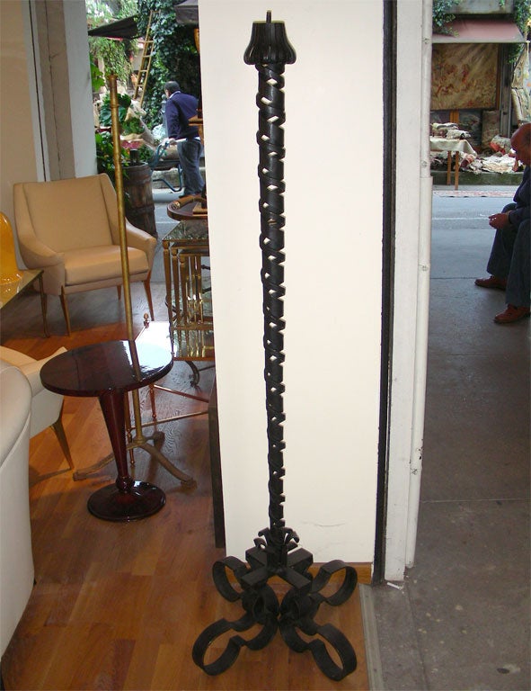 1940 black wrought iron floor lamp by P. Sube with torsaded stem and four curling feet.