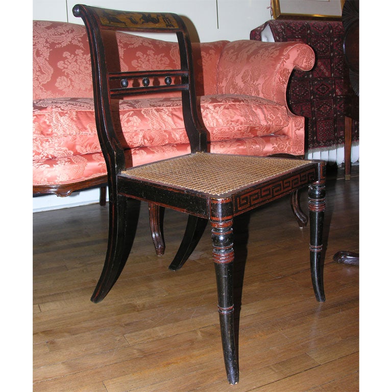 Pair of English, Regency black lacquered and painted side chairs<br />
with caned seats and velvet cushions.