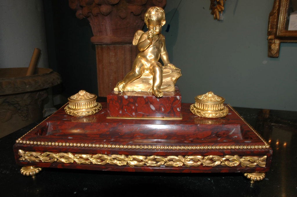 Rouge marble and gilt bronze inkwell with seated angel, in the neoclassical style, signed 