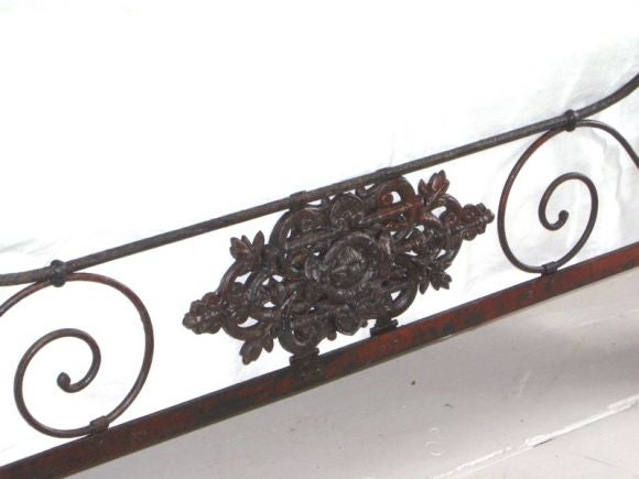 Folding iron campaign bed with traces of old red paint. Decoration on one side onlly.