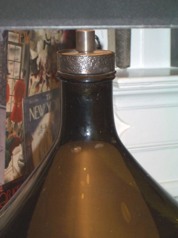 Large dark green/amber French wine bottle, converted to a lamp. Antique patinated double cluster lights, silk cord.