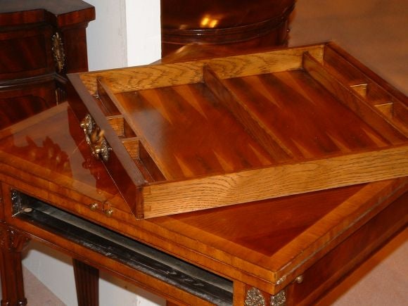 GAME TABLE WITH FOLDING LEAVES. FRONT DRAWER INCLUDES BACKGAMMON. CHESS GAME ON TOP. ELABORATE PARQUETRY THROUGHOUT. BANDED TOP AND APRON. LEGS COMPOSED OF MULTIPLE JOINED DORIC COLUMNS, REINFORCED WITH CURVILINEAR LOWER FRAME. TWO SHADES OF