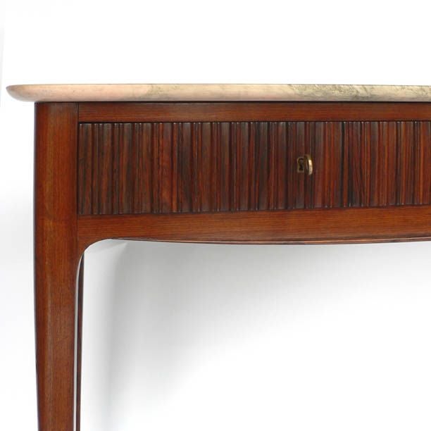 A very elegant modernist console table attributed to Paolo Buffa and executed in mahogany with two drawers having fluted rosewood facades, the legs finished by brass sabots. Original marble top. Outer face of one drawer body marked 
