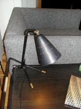 Small lamp in perforated black metal with gold feet and joint. Small lamp in perforated black metal with gold feet and joint.