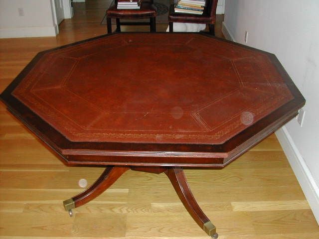 Mahogany leather topped octagonal library table. Gold embossed border detail. Four splayed legs on casters. Can also be used as card table.