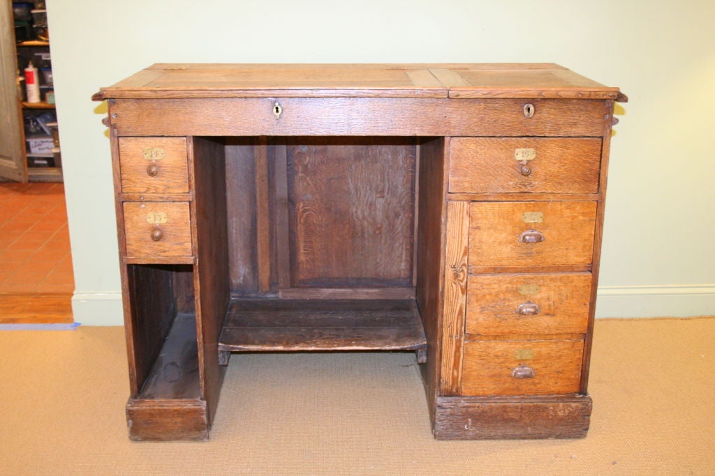 French 19th Century solid oak store counter with two upper compartments and 7 numbered  drawers. Original brass slot for coins.