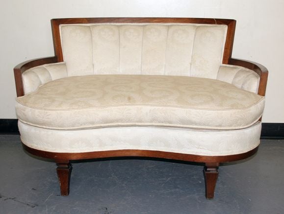 Pair of kidney-shaped sofas with mahogany trim.