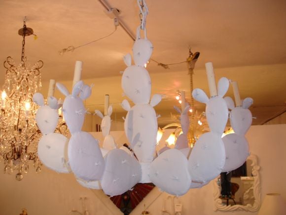 A white painted metal chandelier in the form of a cactus.