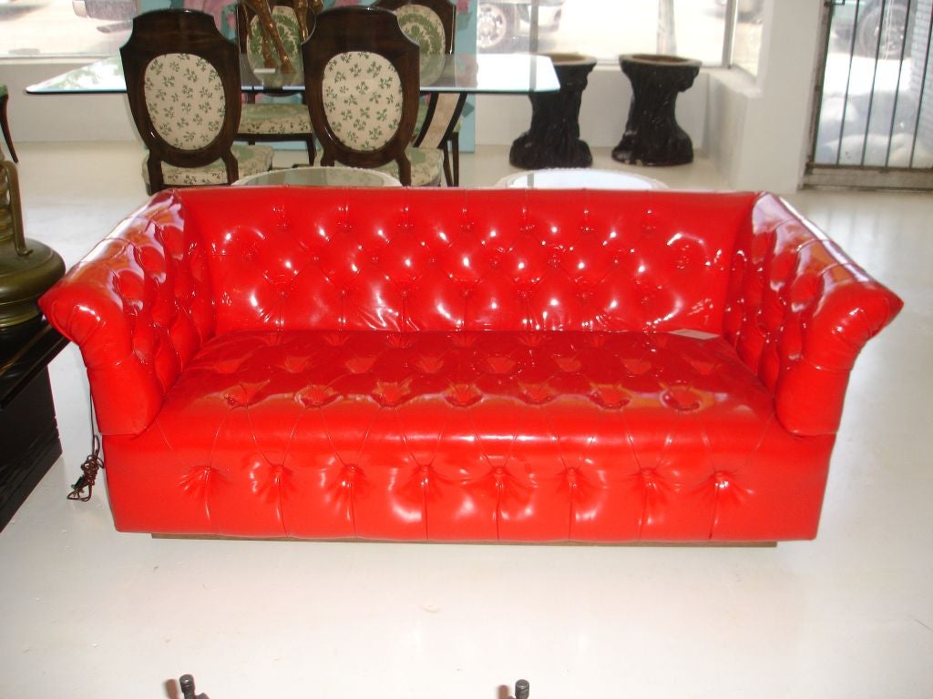 A most unusual red patent leather chesterfield loveseat by Thayer Coggin. Beautifully floats and a wood stretcher.