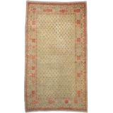 A KHOTAN CARPET MAIZE GROUND AND POMEGRANITE ACCENTS A KHOTAN CARPET MAIZE GROUND AND POMEGRANITE ACCENTS