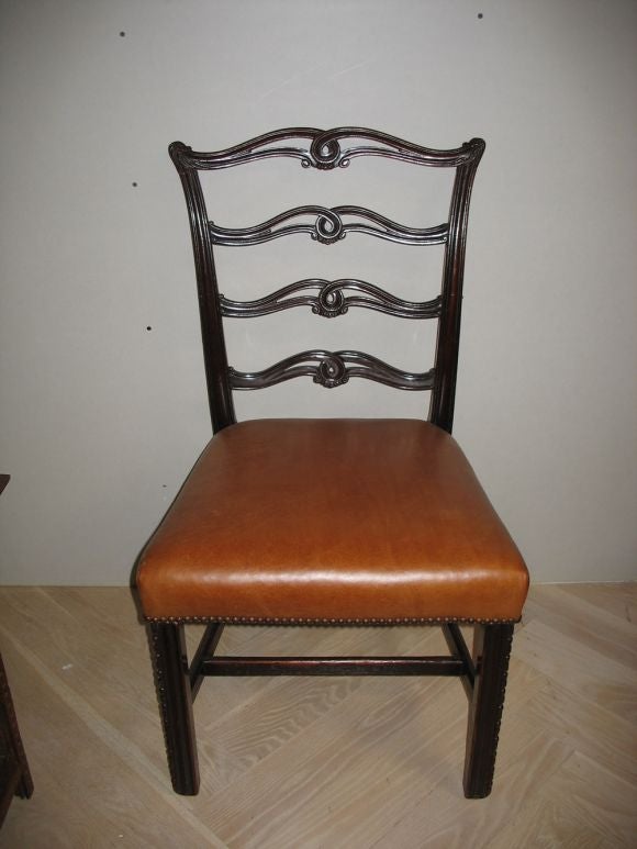 Classic Chippendale mahogany ladderback chairs upholstered in leather.  Good large scale, color, and patina.  These chairs are sturdy.